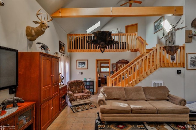 tiled living room with beam ceiling, a skylight, high vaulted ceiling, and ceiling fan