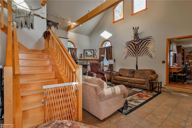 tiled living room featuring a healthy amount of sunlight, beam ceiling, high vaulted ceiling, and track lighting