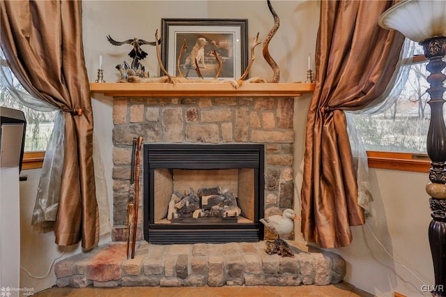 interior details featuring tile patterned floors and a stone fireplace