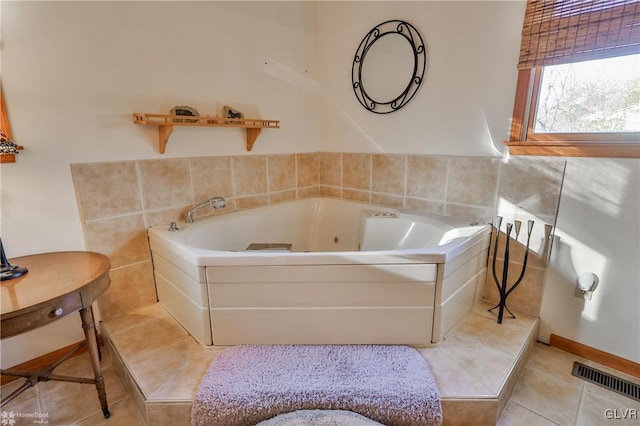 bathroom with tile patterned flooring and a relaxing tiled tub