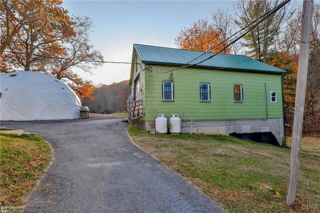 3479 Mango Dr, Lehigh Township, PA 18038 - view of side of home featuring metal roof, a lawn, and driveway