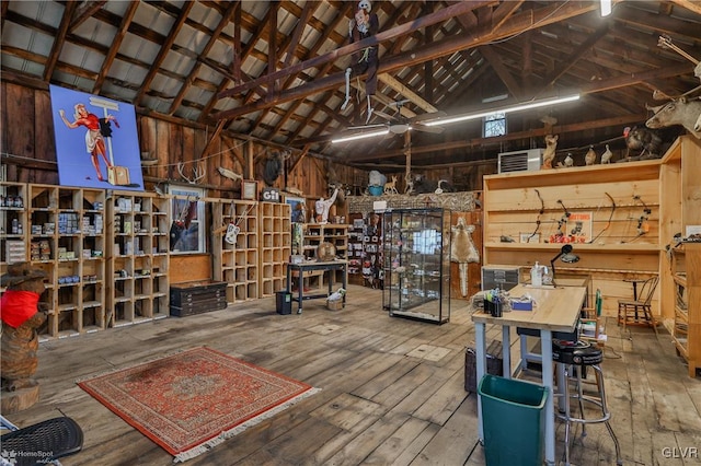 misc room with hardwood / wood-style flooring, high vaulted ceiling, and wooden walls