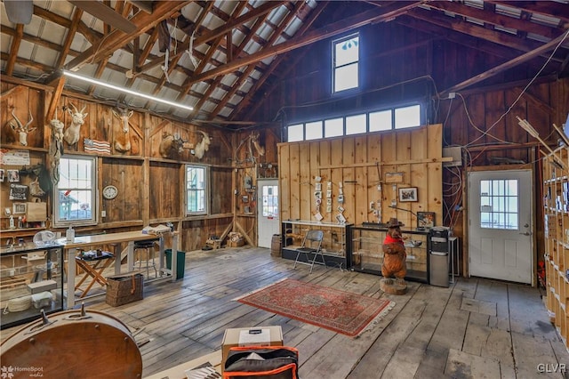 miscellaneous room featuring a workshop area, hardwood / wood-style floors, and high vaulted ceiling