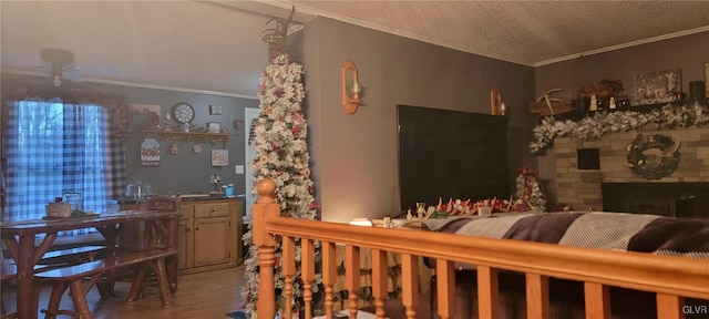 wine cellar featuring a textured ceiling, a stone fireplace, light wood-type flooring, and crown molding