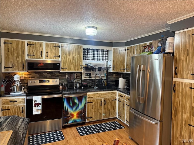 kitchen featuring stainless steel appliances, a sink, ornamental molding, brown cabinets, and dark countertops