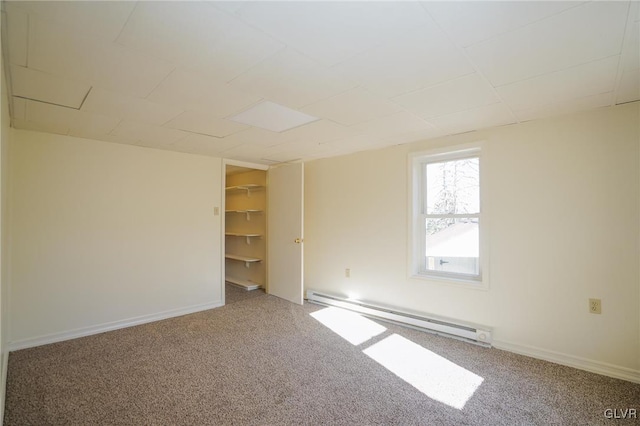 unfurnished room featuring carpet and a baseboard heating unit