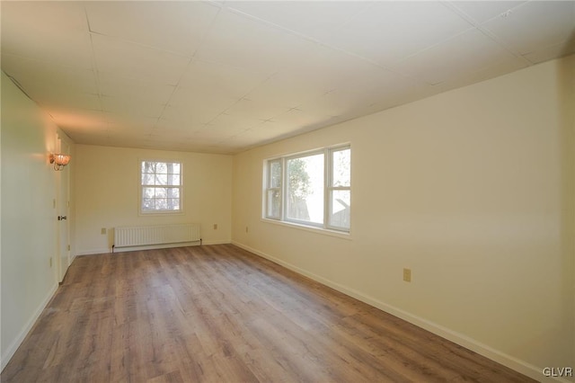 spare room with radiator and wood-type flooring