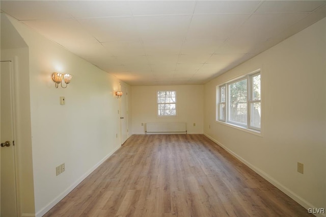 spare room featuring radiator and light wood-type flooring