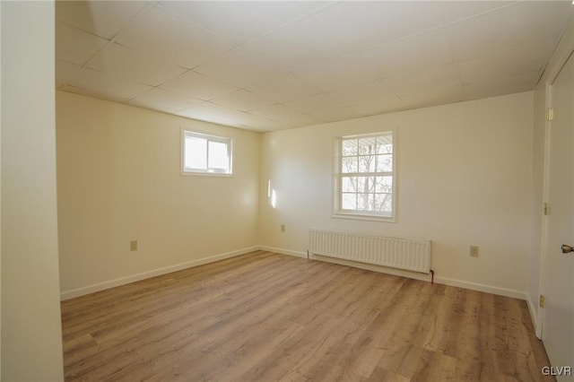 empty room with light wood-type flooring and radiator