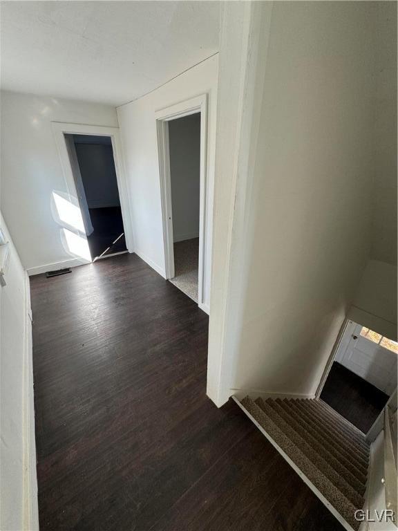 hallway with dark hardwood / wood-style floors