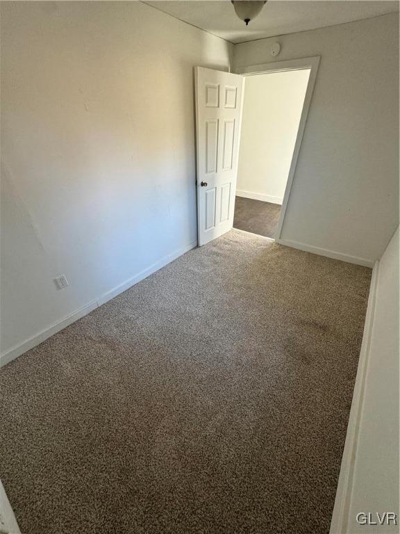 spare room with dark carpet