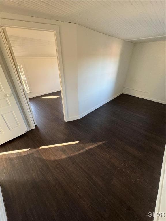 unfurnished room with dark wood-type flooring