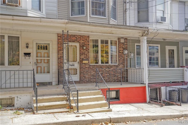 doorway to property with a porch and cooling unit