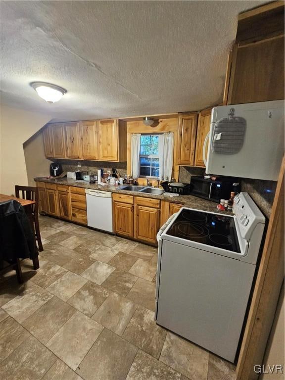 kitchen with a textured ceiling, white appliances, tasteful backsplash, and sink