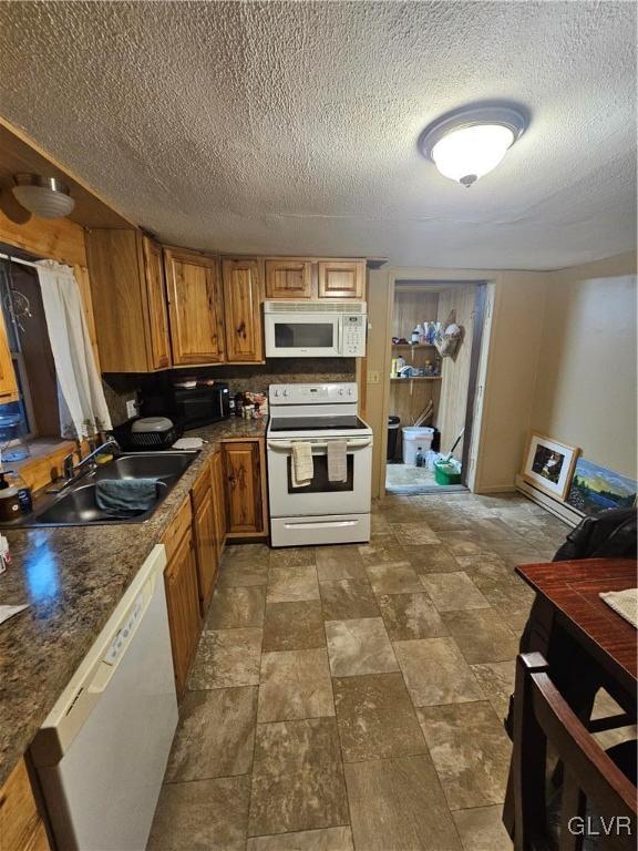 kitchen featuring a textured ceiling, decorative backsplash, sink, and white appliances