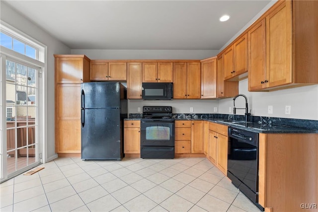 kitchen featuring dark stone counters, sink, light tile patterned flooring, and black appliances