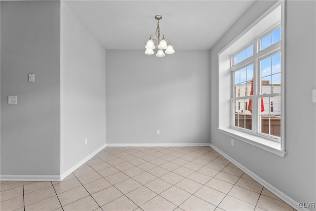 unfurnished room featuring light tile patterned flooring and an inviting chandelier