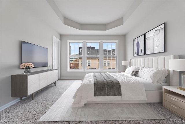 carpeted bedroom with a tray ceiling