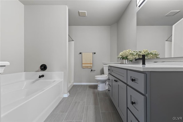 bathroom featuring a bath, vanity, and toilet