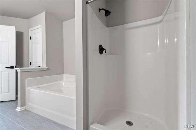 bathroom featuring tile patterned flooring and shower with separate bathtub