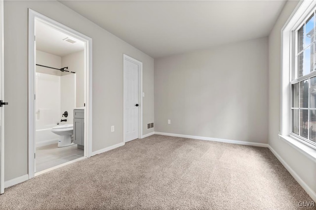 unfurnished bedroom with light carpet and ensuite bathroom