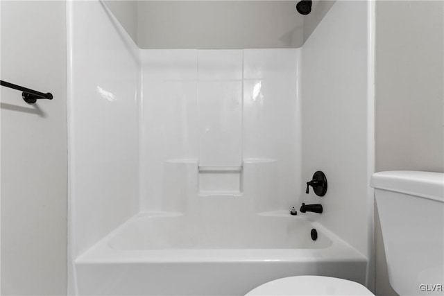 bathroom featuring bathtub / shower combination and toilet