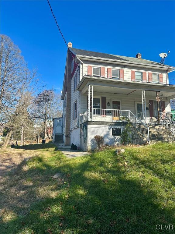 view of front of home with a porch and a front yard