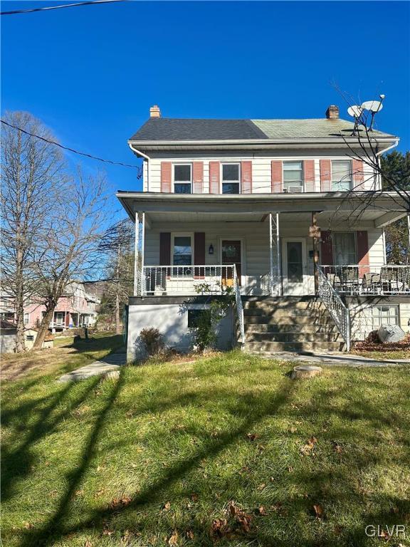 view of front facade with a front lawn and a porch