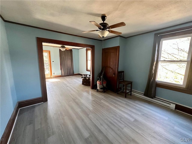 interior space with light hardwood / wood-style flooring, a wealth of natural light, a baseboard radiator, and ornamental molding