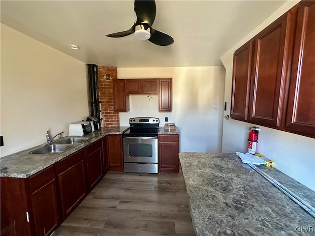 kitchen featuring ceiling fan, stainless steel range with electric stovetop, dark hardwood / wood-style flooring, and sink