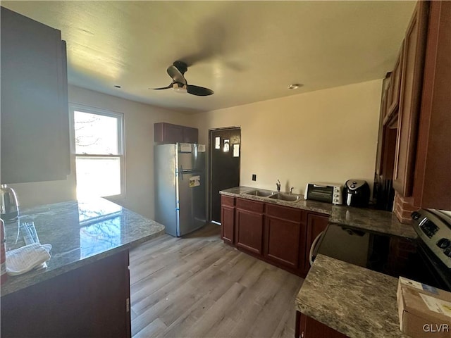 kitchen with stainless steel appliances, ceiling fan, sink, and light wood-type flooring