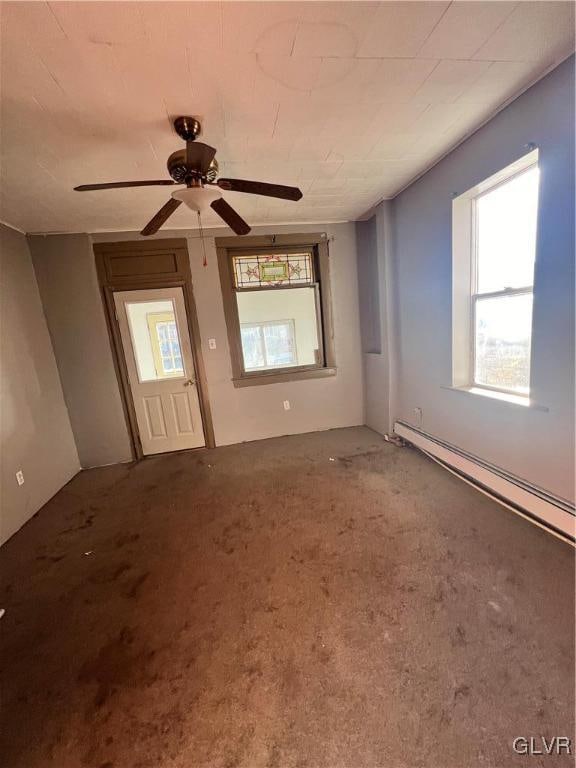 unfurnished room featuring ceiling fan, carpet floors, and a baseboard heating unit