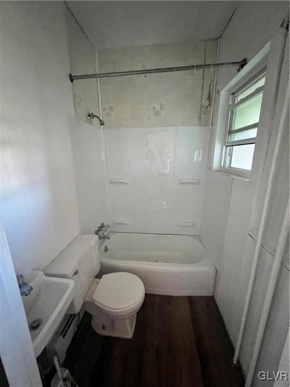 bathroom with hardwood / wood-style floors, shower / bathing tub combination, and toilet