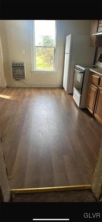 kitchen with heating unit, white electric stove, and dark wood-type flooring