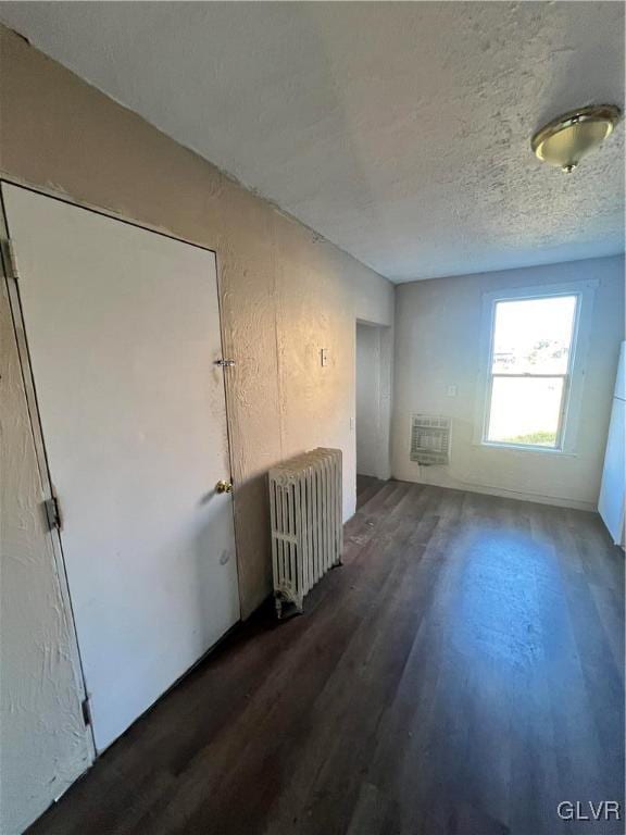 unfurnished room with radiator heating unit and dark wood-type flooring