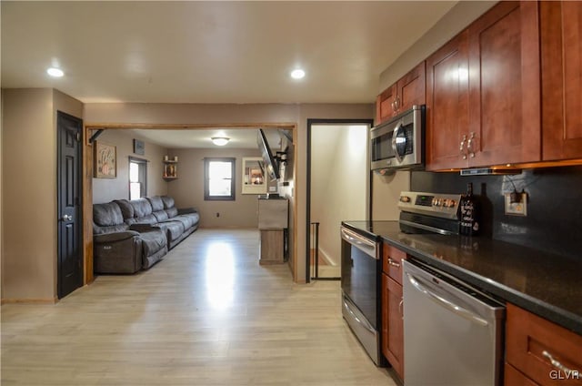 kitchen with light hardwood / wood-style flooring and appliances with stainless steel finishes