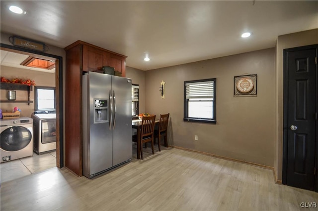 kitchen with stainless steel fridge, washing machine and dryer, and light wood-type flooring