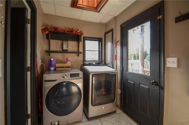 washroom with separate washer and dryer and a healthy amount of sunlight