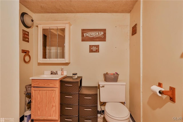 bathroom with vanity, a textured ceiling, and toilet