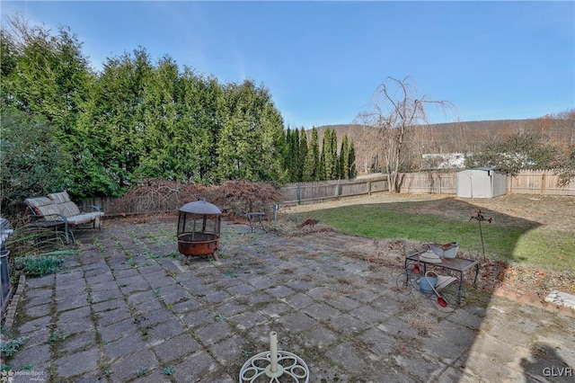 view of patio / terrace featuring a shed and an outdoor fire pit