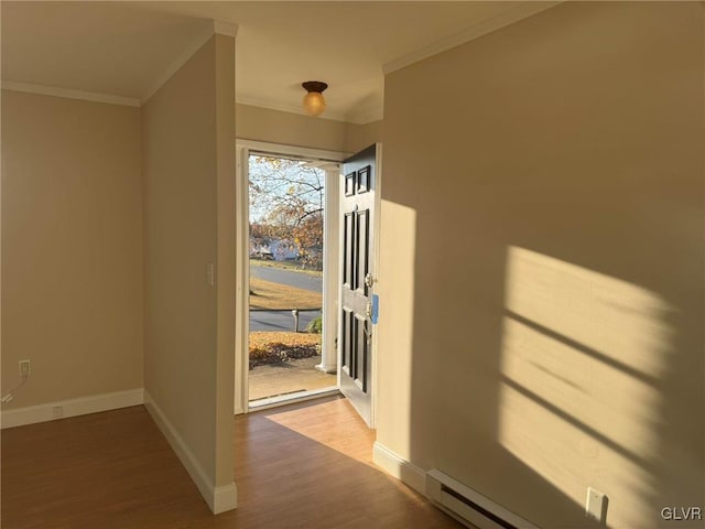 entryway with hardwood / wood-style floors, baseboard heating, and ornamental molding