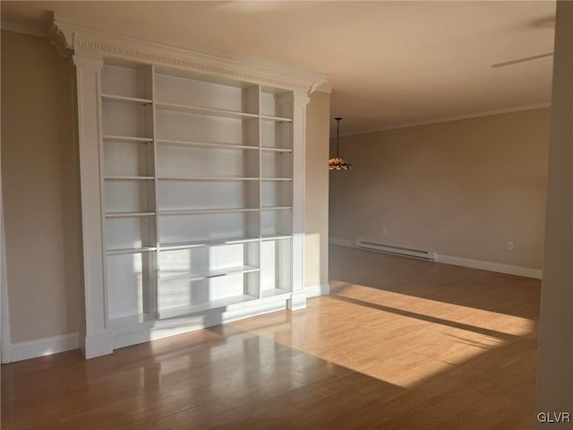 empty room featuring hardwood / wood-style flooring, ornamental molding, and baseboard heating