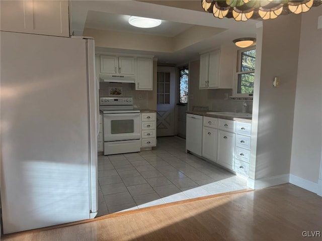 kitchen featuring white appliances, backsplash, white cabinets, sink, and light hardwood / wood-style flooring