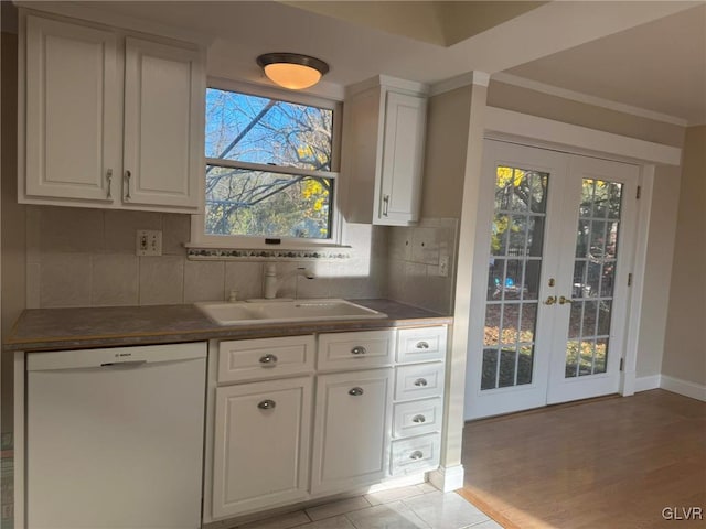 kitchen with dishwasher, backsplash, french doors, white cabinets, and sink