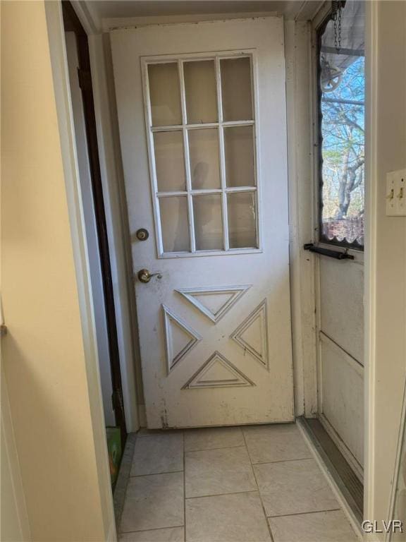 doorway to outside with light tile patterned floors