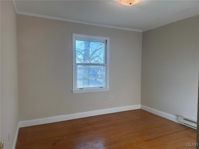 spare room with hardwood / wood-style floors, ornamental molding, and baseboard heating