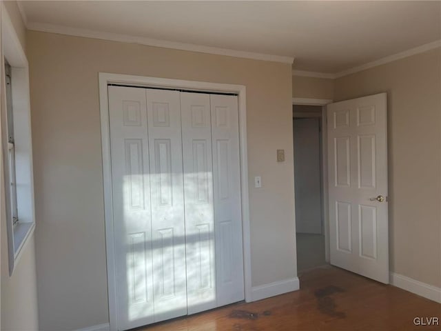 unfurnished bedroom with a closet, hardwood / wood-style floors, and ornamental molding