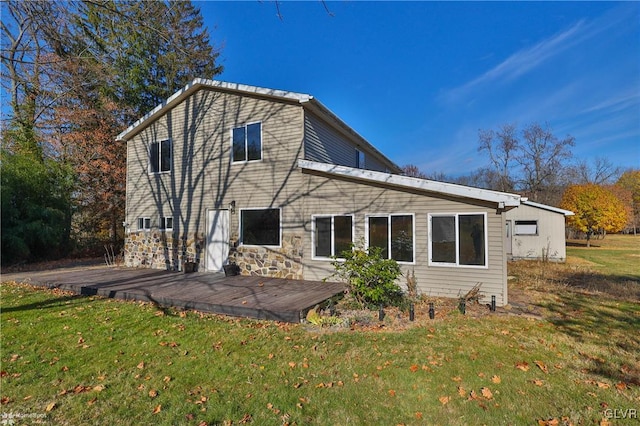 rear view of house featuring a lawn and a wooden deck