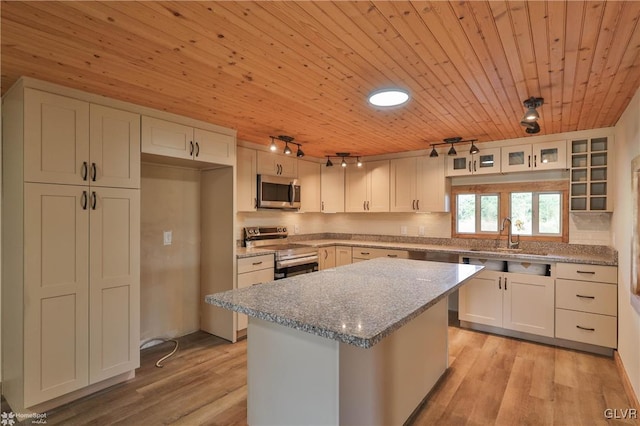 kitchen featuring a center island, rail lighting, appliances with stainless steel finishes, light hardwood / wood-style floors, and white cabinetry