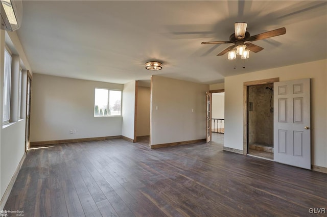 spare room with dark hardwood / wood-style flooring, an AC wall unit, and ceiling fan